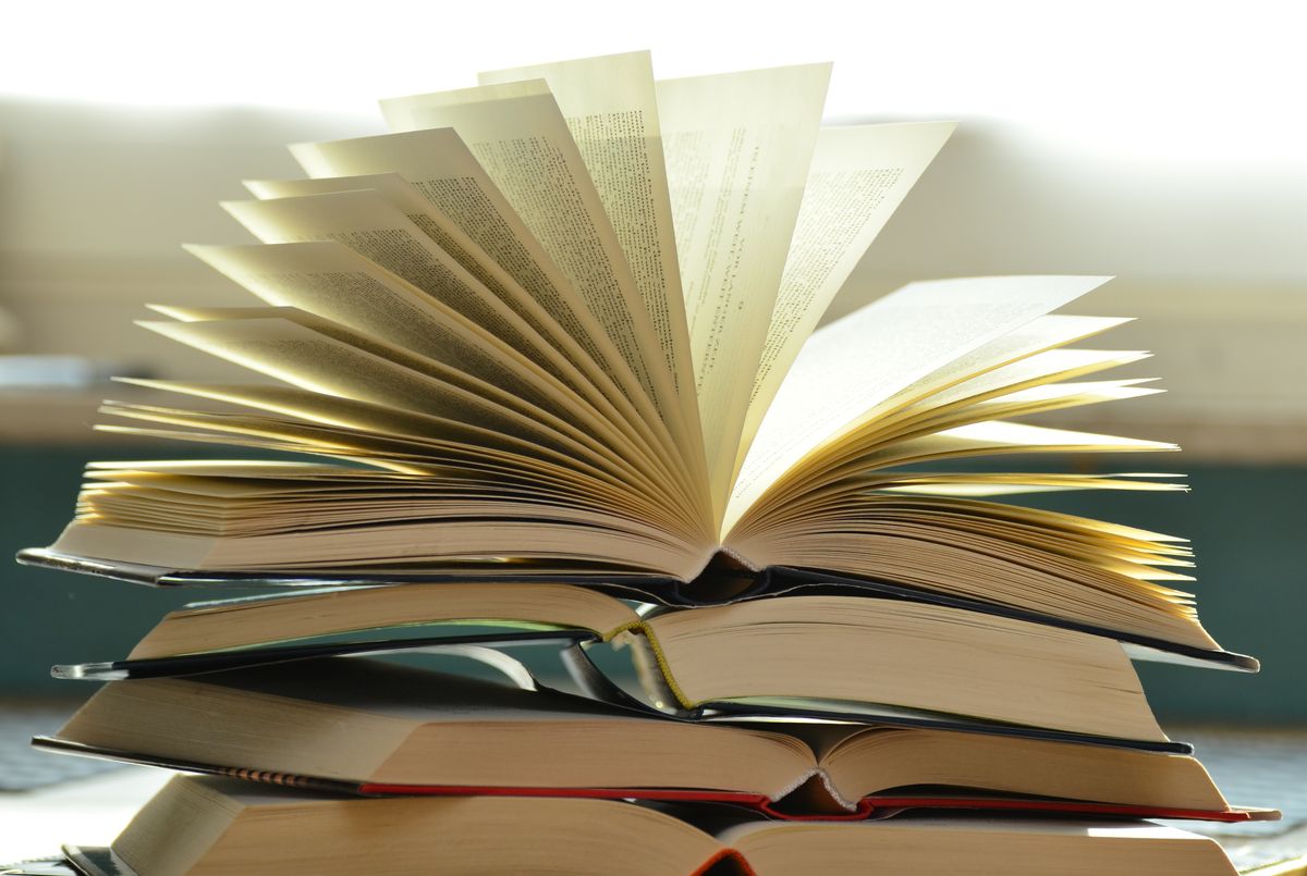 Stack of open books fanned out, representing a book marketing strategy that keeps selling copies after launch
