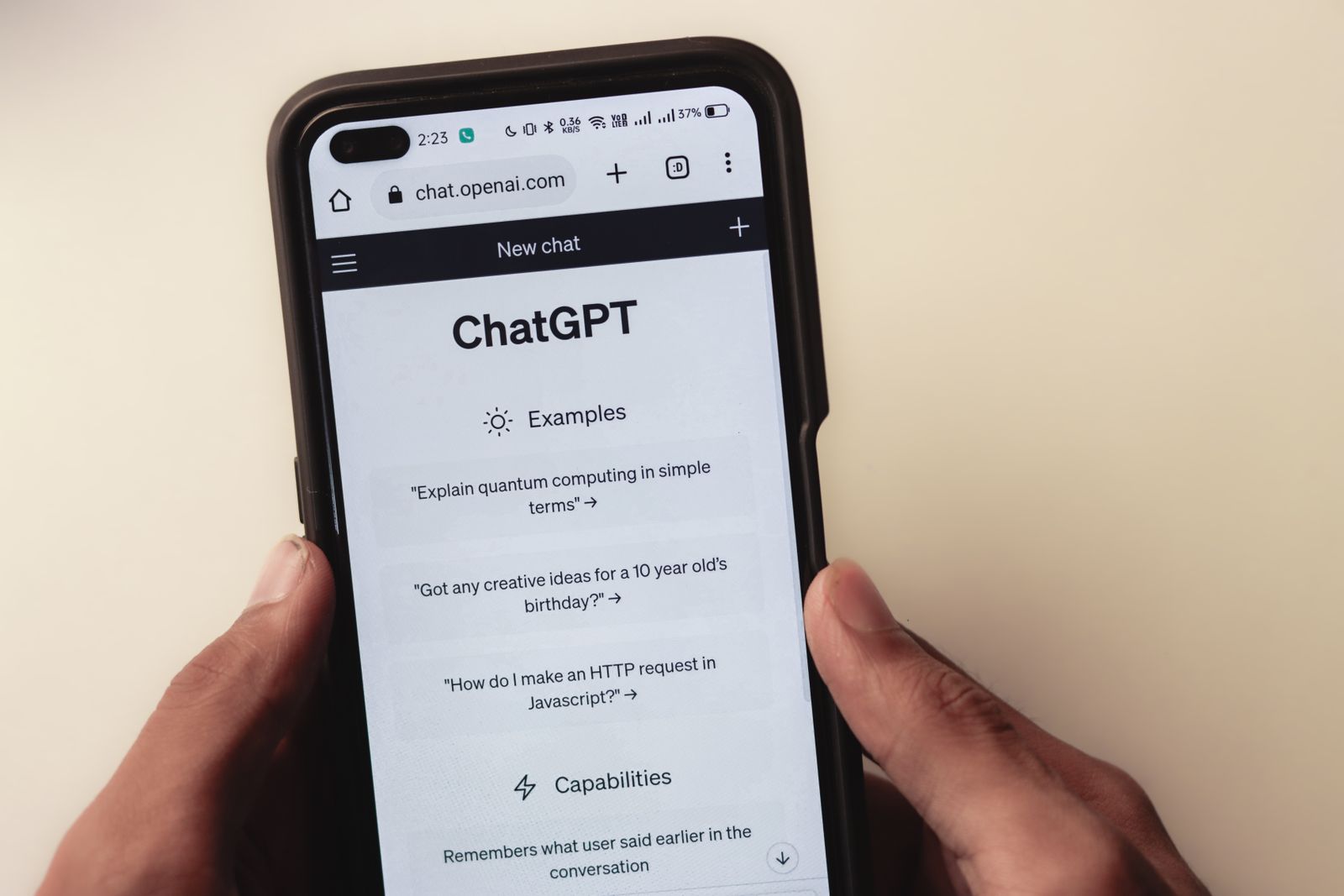 A person holding a smartphone displaying the ChatGPT interface