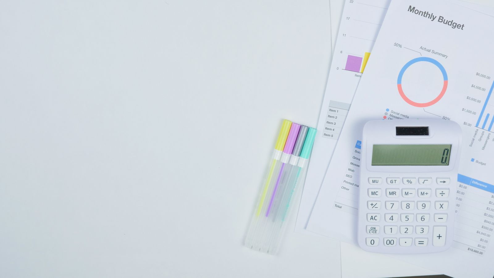 A monthly budget worksheet and calculator on a desk