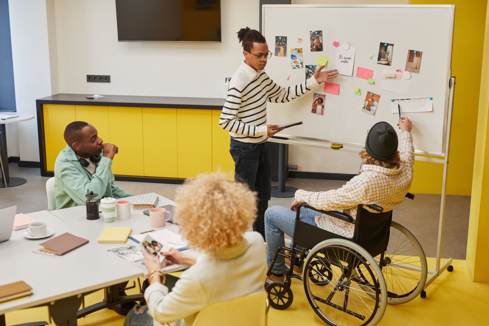 A team planning a project together around a whiteboard in a meeting room