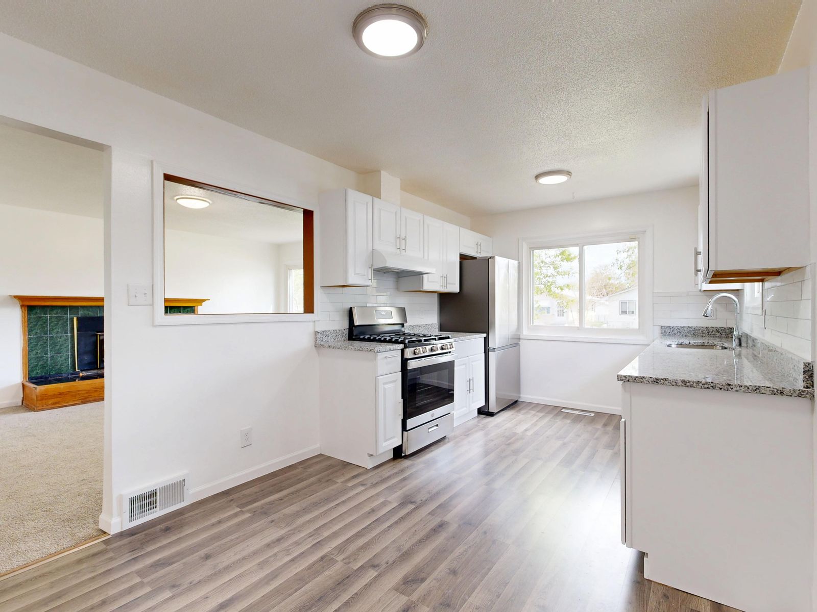 Newly renovated kitchen with white cabinetry and updated flooring